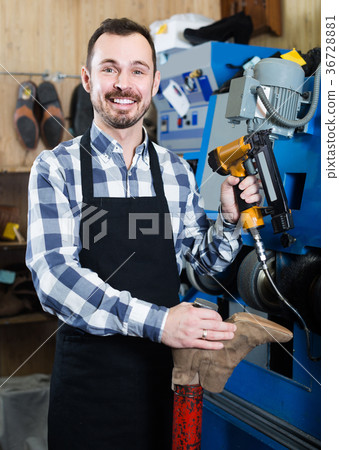 male worker fixing failed shoes in shoe repair workshop 36728881