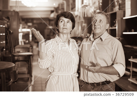 positive adult woman with her husband are buying furniture in antique store positive adult woman with her husband are buying furniture in antique store 36729509