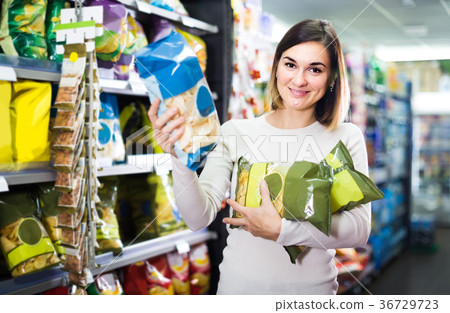 woman choosing delicious snacks in supermarket 36729723