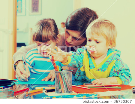 Mother and siblings playing with pencils Mother and siblings playing with pencils 36730307
