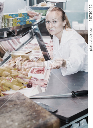 Woman showing product in delicatessen section Woman showing product in delicatessen section 36730452
