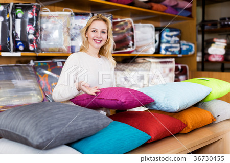 Woman seller displaying various home textiles 36730455