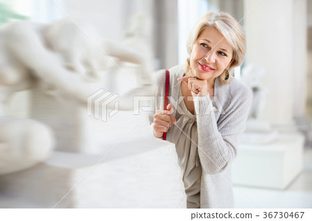 Adult female looking at artwork sculpture in the museum indoors 36730467
