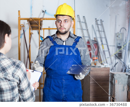Professional constructor with spatula is clarifying details from client Professional constructor with spatula is clarifying details from client 36730488
