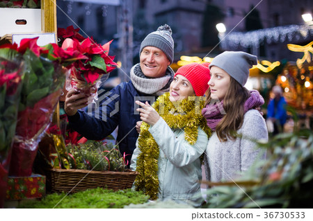 Pretty family of three choosing floral decorations Pretty family of three choosing floral decorations 36730533