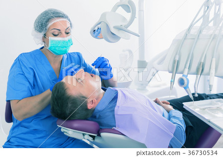 adult dentist checking teeth of patient adult dentist checking teeth of patient 36730534
