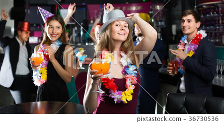 Portrait of young friendly women and men in caps with cocktails Portrait of young friendly women and men in caps with cocktails 36730536