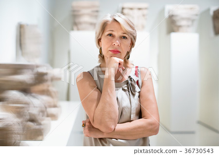 Positive woman in art museum near the antique classical sculpture Positive woman in art museum near the antique classical sculpture 36730543