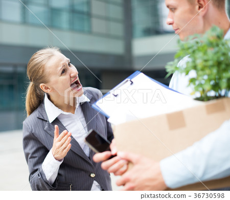 Irate woman is dismissing young manager for violating the job description Irate woman is dismissing young manager for violating the job description 36730598