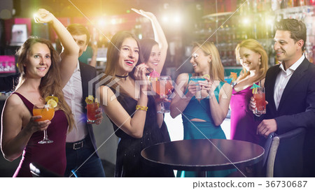 Colleagues dancing on corporate party with cocktails in hands Colleagues dancing on corporate party with cocktails in hands 36730687