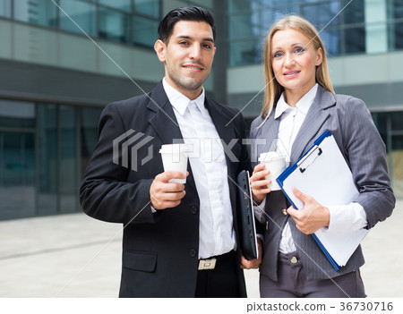 Portrait of couple who are standing with folder and coffee Portrait of couple who are standing with folder and coffee 36730716