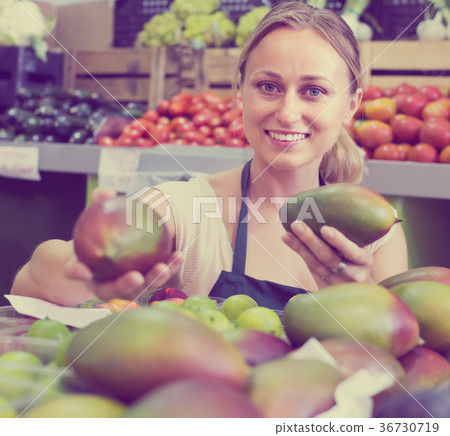 young woman selling mango at market . young woman selling mango at market . 36730719