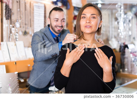 man helps to trying chainlet and pendants 36730806