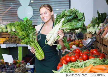 Seller holding fresh celery and mangold 36730907