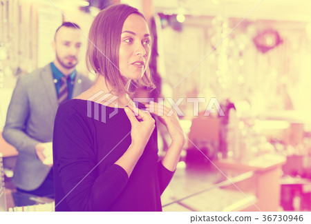 Female consumer trying chainlet with pendants 36730946