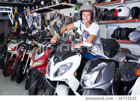 Portrait of glad male in helmet on motorbike in the store 36731035