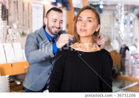 man helps to trying chainlet and pendants 36731206