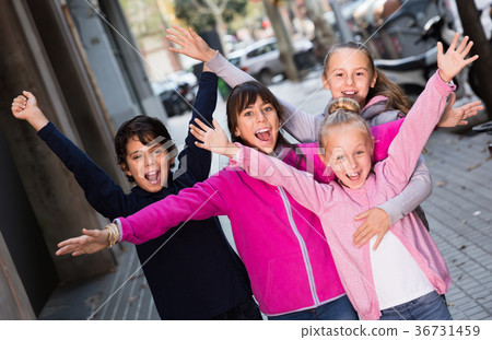 four cheerful children play without parents on sidewalk in modern city four cheerful children play without parents on sidewalk in modern city 36731459