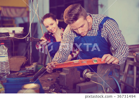 Portrait of master who is working with level in workshop. 36731494