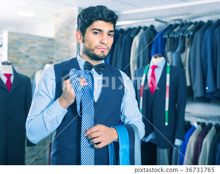 Smiling man is picking up tie for waistcoat Smiling man is picking up tie for waistcoat 36731765