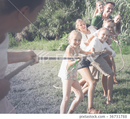 Laughing kids with parents playing tug of war 36731788