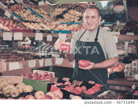Man seller demonstraiting red tomatos Man seller demonstraiting red tomatos 36731849