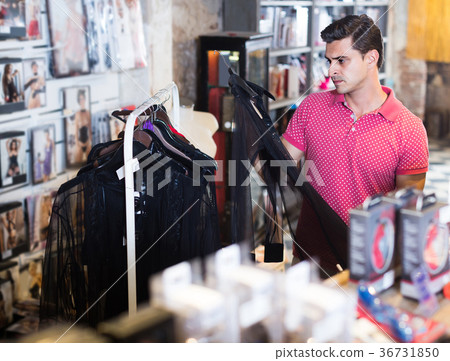 Buyer man choosing black sexual shirt in the sex shop Buyer man choosing black sexual shirt in the sex shop 36731850