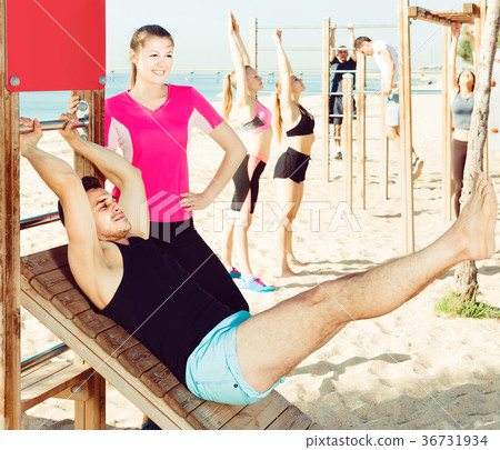 Sporty women and men during training outdoors on sunny beach Sporty women and men during training outdoors on sunny beach 36731934