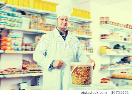 Cheerful salesman offering salted olives 36731961