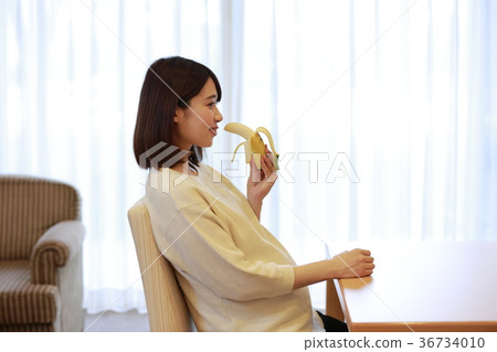 Maternity woman eating banana 36734010