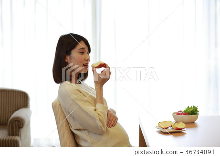Maternity woman eating an apple 36734091