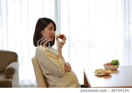 Maternity woman eating an apple 36734104
