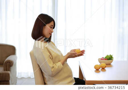 Maternity woman looking at lemon 36734215