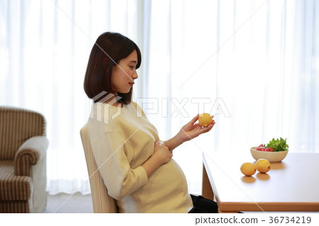 Maternity woman looking at lemon Maternity woman looking at lemon 36734219