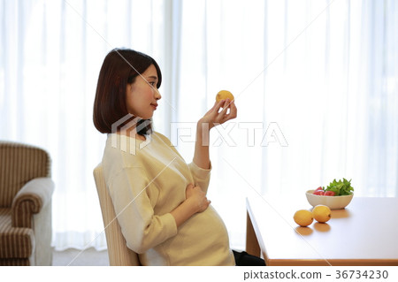 Maternity woman looking at lemon Maternity woman looking at lemon 36734230