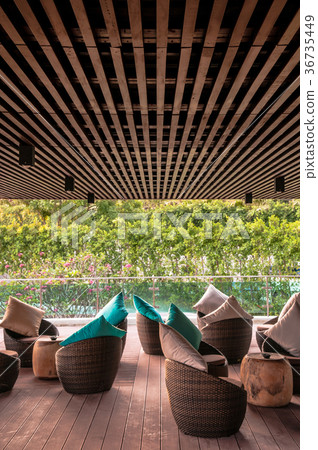 Resort lounge with wooden stools and blue pillow 36735449