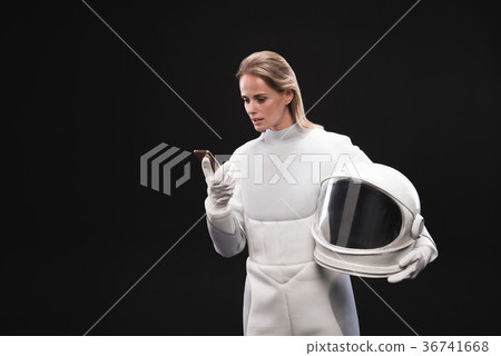 Trained woman cosmonaut is using smartphone 36741668