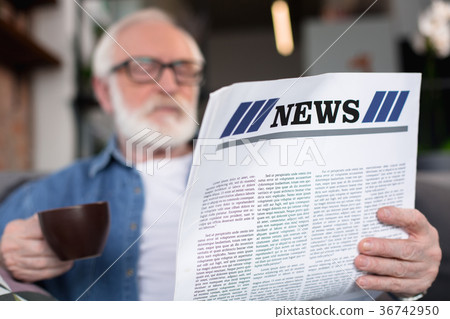 Mature gentleman reading news with coffee 36742950