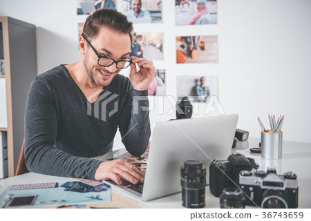 Outgoing retoucher working with laptop Outgoing retoucher working with laptop 36743659