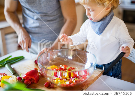 Young father with a toddler boy cooking. 36745166