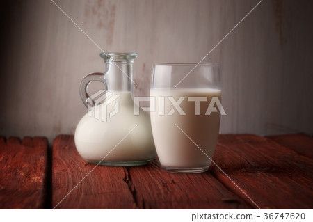 Fresh milk in glass jug and glass on wooden Fresh milk in glass jug and glass on wooden 36747620