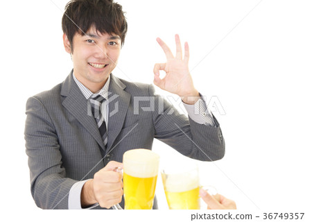 Smiling office worker drinking beer Smiling office worker drinking beer 36749357