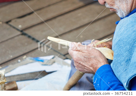 the artisan makes a spoon of wood 36754211