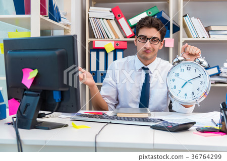 Businessman working in the office with piles of 36764299