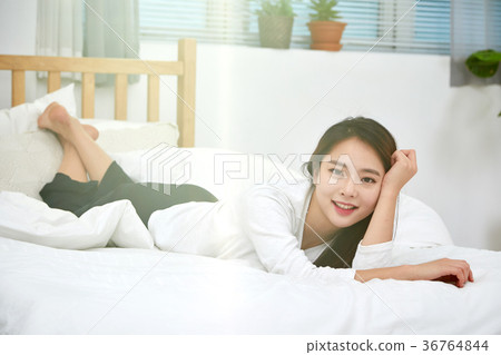 一個女人在床上有一個輕鬆的下午 一個女人在床上有一個輕鬆的下午 36764844