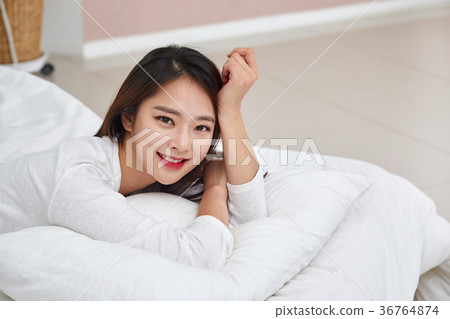 A woman having a relaxing afternoon in bed A woman having a relaxing afternoon in bed 36764874