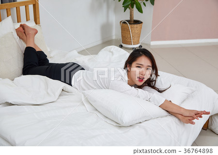 A woman having a relaxing afternoon in bed A woman having a relaxing afternoon in bed 36764898