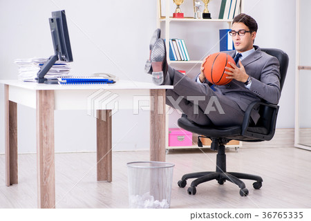 Young businessman playing basketball in office 36765335
