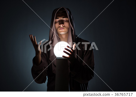 Young wizard with crystal ball in dark room Young wizard with crystal ball in dark room 36765717