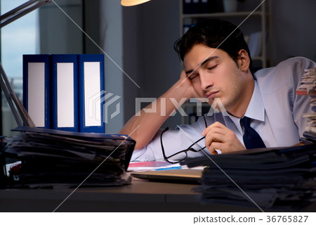 Young businessman working overtime late in office Young businessman working overtime late in office 36765827
